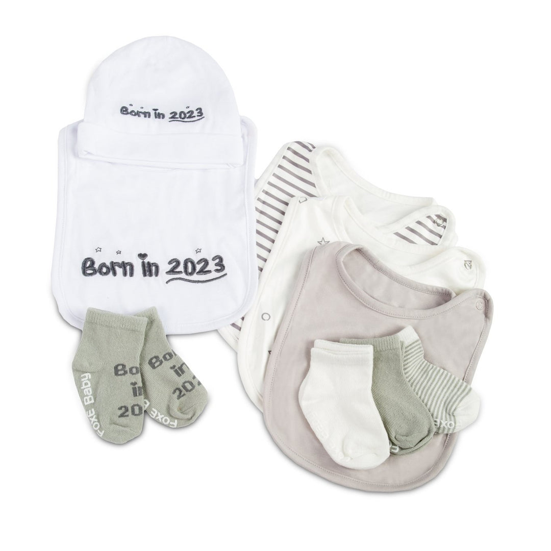 A grey Born In 2023 Gift Set including 4 bibs, 4 pairs of soft cotton socks, and a cute baby beanie.